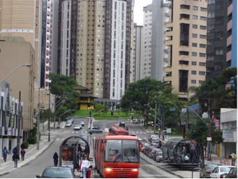 Curitiba: High-rise towers flank iconic tubular bus stations. Note the modern buses.